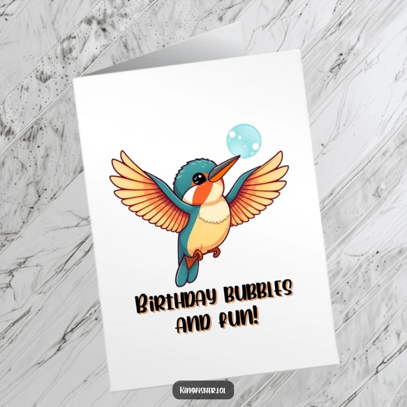 Funny Free Printable Birthday Card showing a charming kingfisher bird with wings outstretched, playfully batting at a floating bubble. DIY gift.